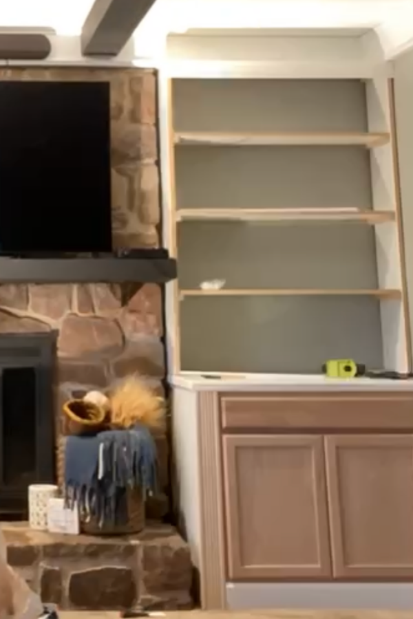 These DIY built ins with stock cabinets are a simple way to create built in shelving in your living room. Built a bookcase on top of a stock cabinet, then trim and paint!  #livingroomdecor #builtins #homewoodworking #diyhomedecor #diyhomeprojects