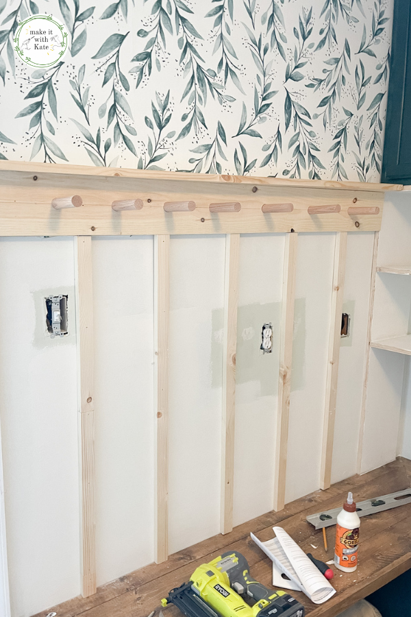 This DIY board and batten with a peg rail top makes the perfect addition to an entryway or mud room design. Super easy to make! #diymudroom #diyboardandbatten #millwork #woodworking #housedesign
